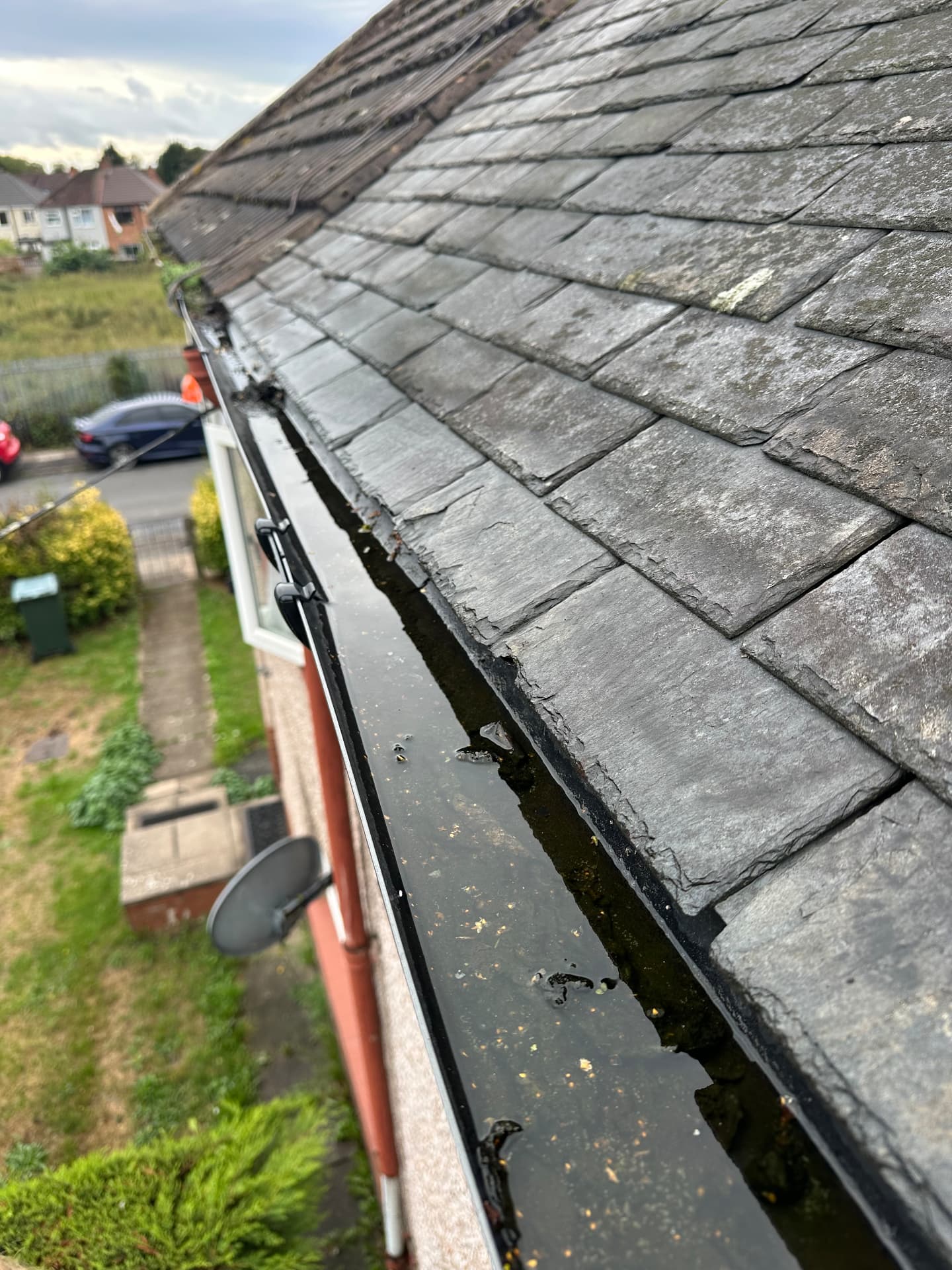 Blocked gutter before gutter cleaning in Coventry, sludge along the full run